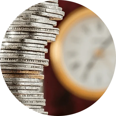 Stack of coins in front of a clock